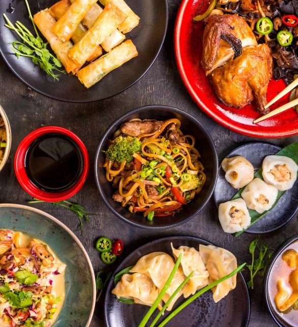 Assorted Chinese food set. Chinese noodles, fried rice, dumplings, peking duck, dim sum, spring rolls. Famous Chinese cuisine dishes on table. Top view. Chinese restaurant concept. Asian style banquet