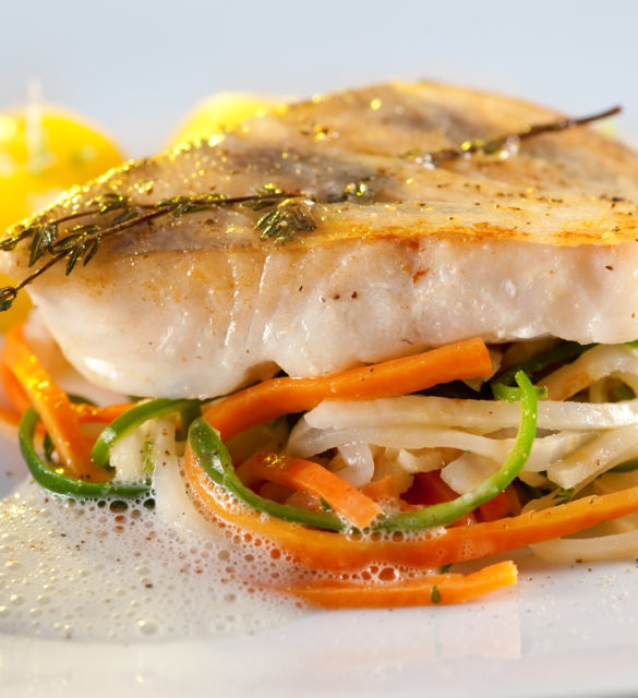Fried pike perch with vegetables: potatoes, on stripes of carrots, cucumber and asparagus in a fluffy sauce.