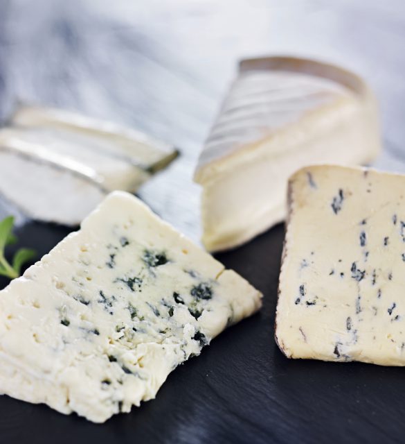 assortment of gourmet artisanal cheeses on slate cheese tray assortment of gourmet artisanal cheeses on slate cheese tray