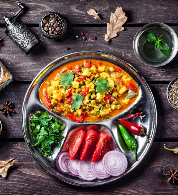 Indian Mutter paneer dish with spices on the wooden background