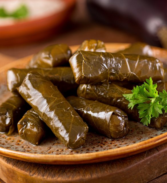 Stuffed Grape Leaves A plate of delicious stuffed grape leaves with parsley garnish.