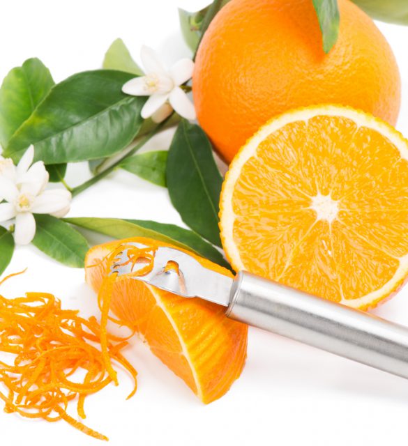 Orange with a zest Orange fruit with leaves and blossom, orange zest with zester isolated on a white background.