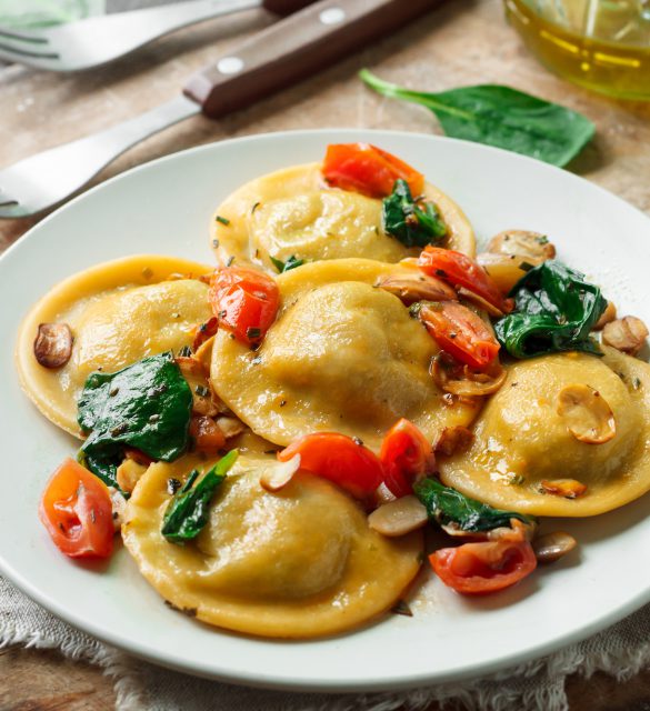 Ravioli with spinach and mushrooms on a wooden background Ravioli with spinach and mushrooms on a wooden background