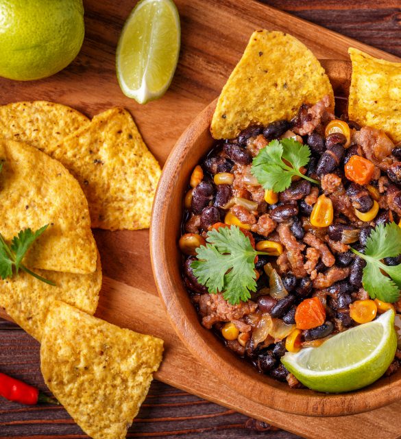 Chili con carne in bowl with tortilla chips. Chili con carne in bowl with tortilla chips on wooden background.